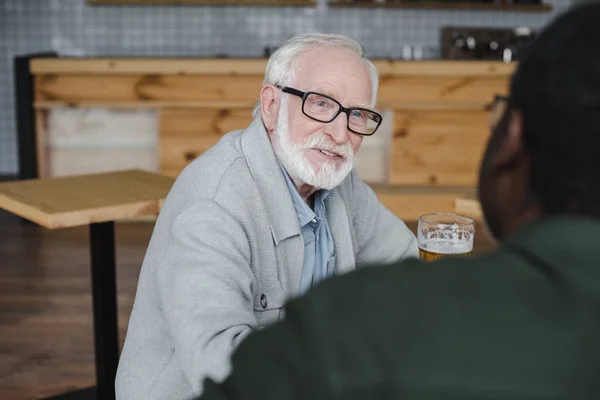 Amigos seniores conversando e bebendo cerveja — Fotografia de Stock