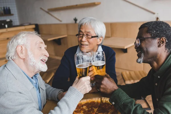 Amigos mayores tintineo vasos de cerveza —  Fotos de Stock