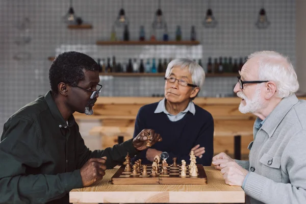 Senior friends playing chess — Stock Photo, Image