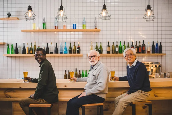 Senior friends drinking beer together — Stock Photo, Image