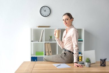 Businesswoman sitting on table with coffee clipart