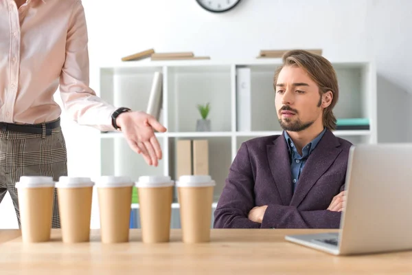 Mujer mostrando en tazas de café desechables — Foto de Stock