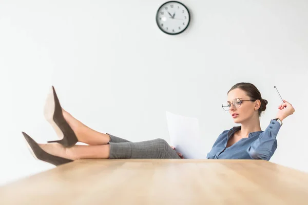 Businesswoman sitting with legs on table — Stock Photo, Image