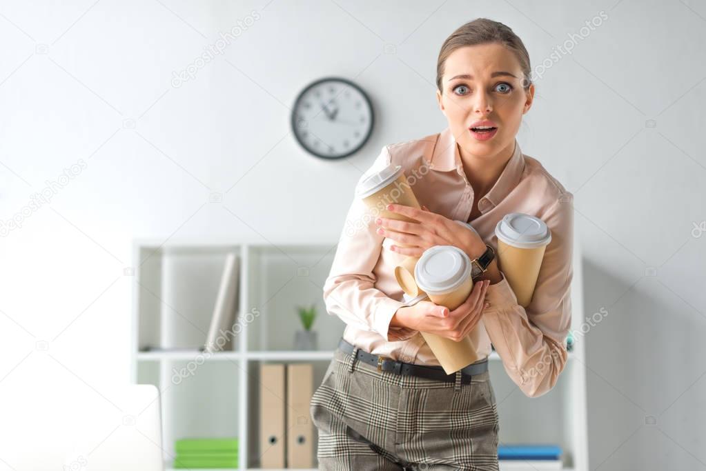 frightened woman with coffee cups