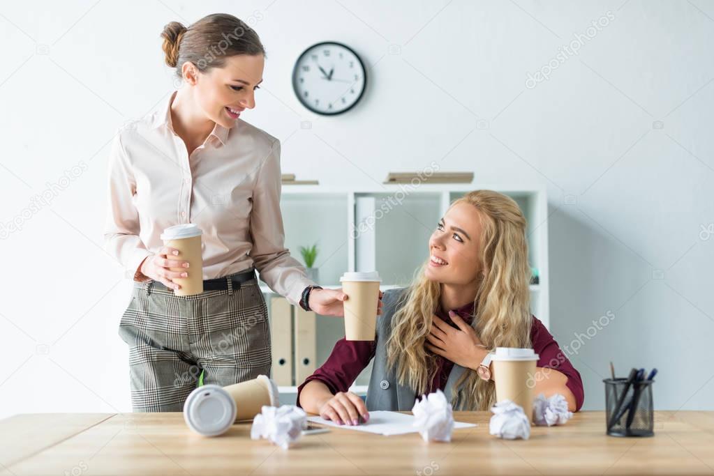 Woman bringing coffee to colleague 