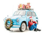 Frau neben Auto mit Weihnachtsgeschenken