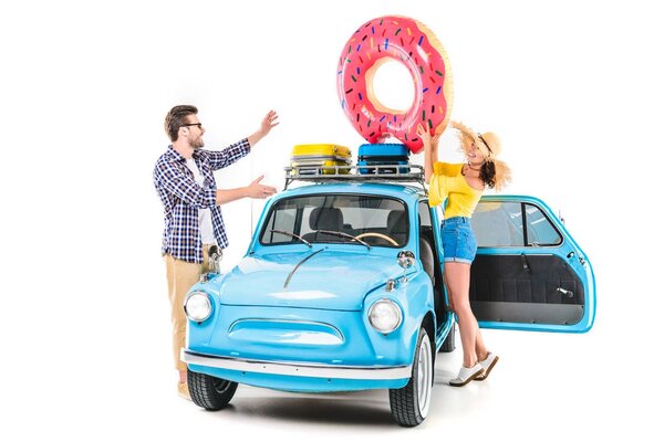 couple putting inflatable donut on car