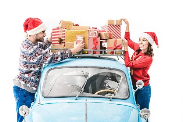 Pareja con regalos de Navidad en el techo del coche — Foto de Stock