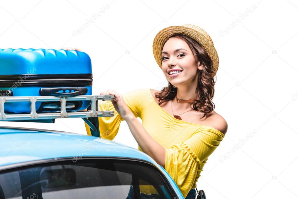 woman putting luggage on car roof