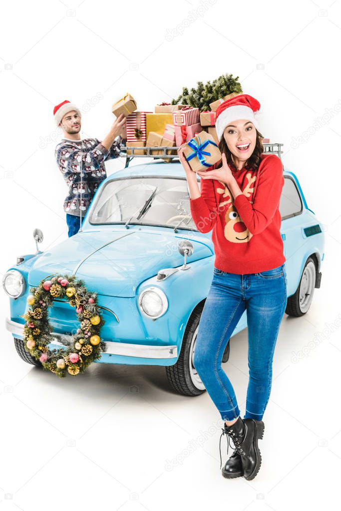 couple with christmas gifts on car roof