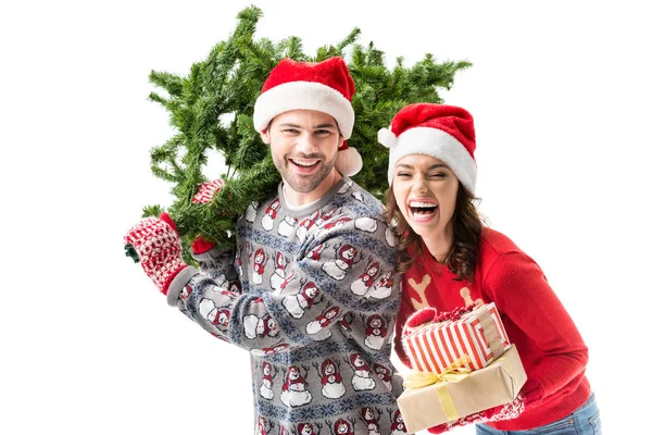 Couple carrying christmas tree and gifts — Stock Photo, Image