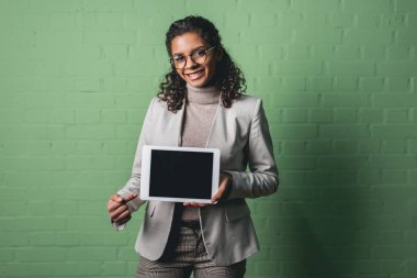 Genç Afro-Amerikan işkadını yeşil duvar önünde dijital tablet sunulması