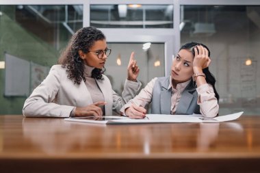 office belgelerinde ile çalışan yorgun ve ciddi çok ırklı iş kadınları 