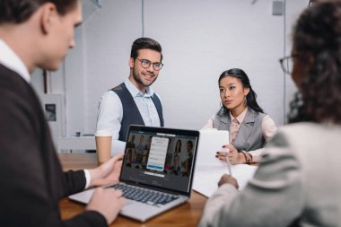 çok ırklı iş takım belgeleri ve LinkedIn Web sitesi ile dizüstü bilgisayar ile
