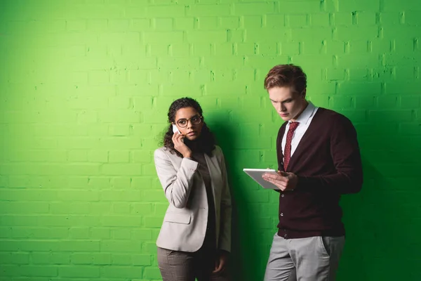 Empresários Multiétnicos Trabalhando Com Tablet Digital Smartphone Frente Parede Verde — Fotografia de Stock