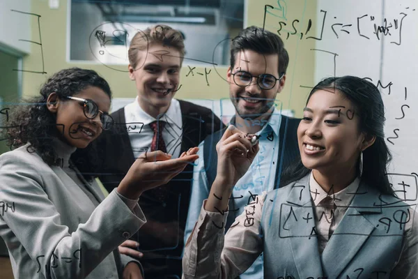 Sonrientes Empresarios Multiétnicos Escribiendo Tablero Cristal Oficina —  Fotos de Stock