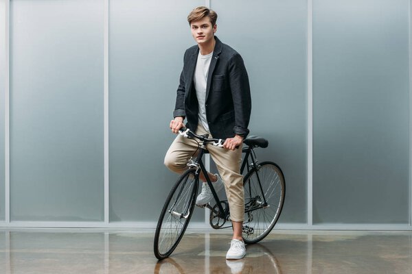 handsome young man on vintage bike indoors