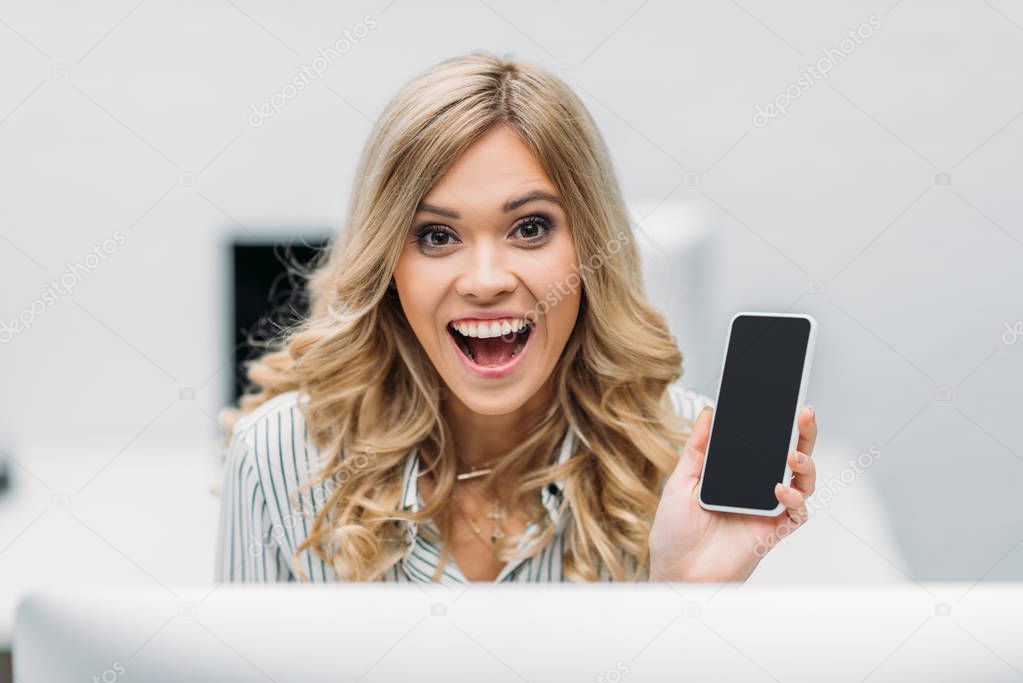 beautiful happy woman with smartphone at modern office