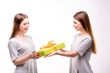 ikiz kardeşi hediye sunma gülümseyen kadın yan görünüm sarılmış