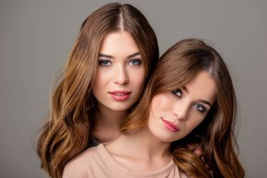 gri izole kamera bakarak parlak makyaj ile güzel ikiz kız portresi