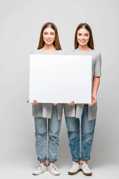 Bellissimi Gemelli Sorridenti Che Tengono Banner Bianco Mani Isolate Grigio — Foto Stock