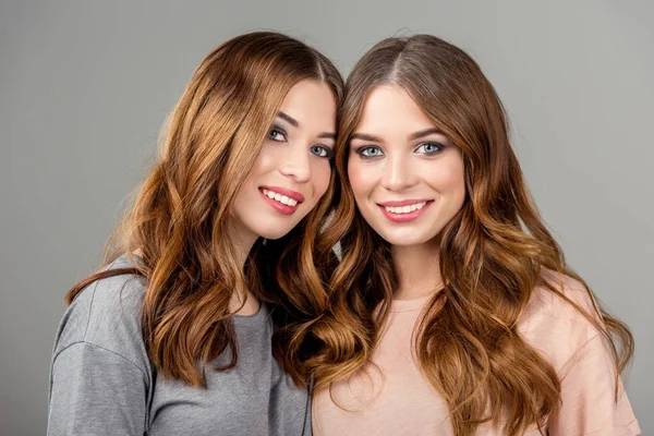 Retrato Belas Irmãs Gêmeas Sorridentes Olhando Para Câmera Isolada Cinza — Fotografia de Stock