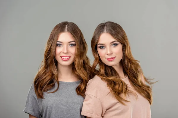 Retrato Hermosas Hermanas Gemelas Sonrientes Aisladas Gris — Foto de Stock