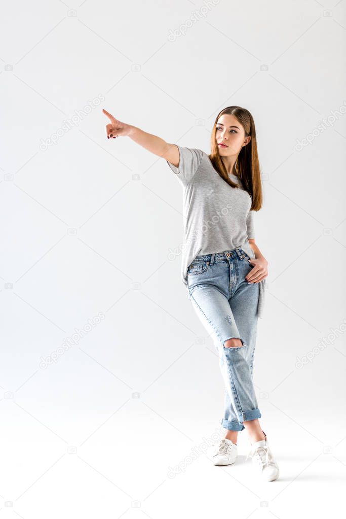 attractive young woman pointing and looking away,  isolated on white