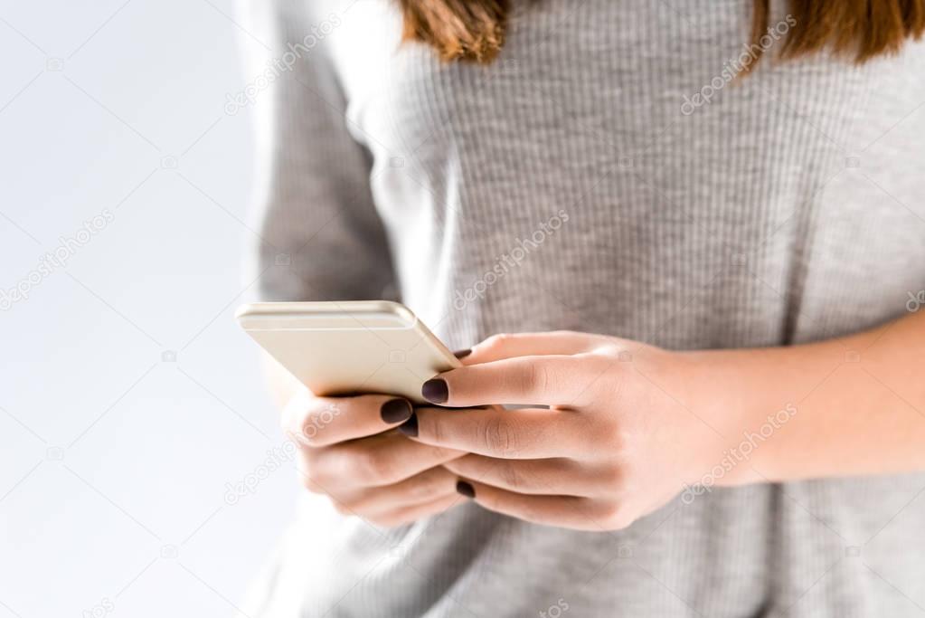 cropped shot of woman holding smartphone in hands,  isolated on white