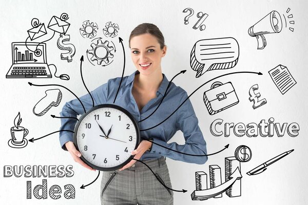 Smiling businesswoman holding wall clock in hands on white with creative business idea inscription and hand-drawn icons