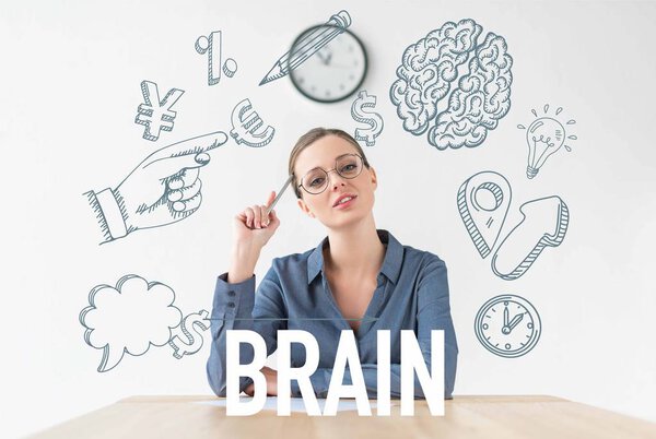thoughtful businesswoman sitting at table and holding pencil in hand, with business icons and brain inscription