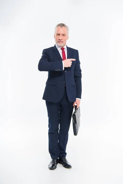 Smiling businessman pointing with finger — Stock Photo
