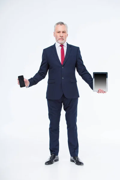 Homem de negócios maduro com dispositivos — Fotografia de Stock