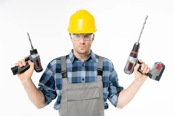 Obrero sosteniendo taladros eléctricos - foto de stock