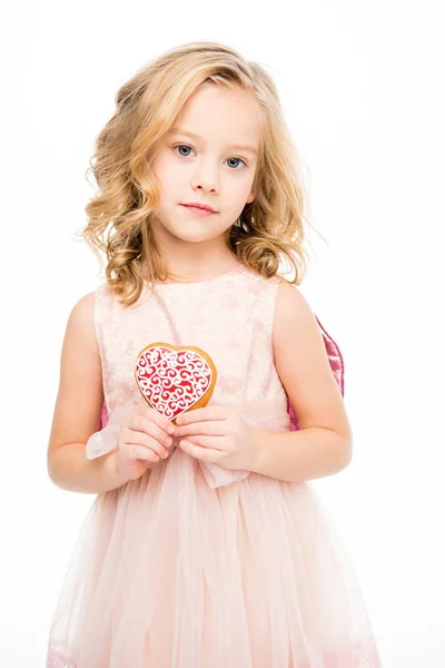 Girl holding heart shaped cookie — Stock Photo