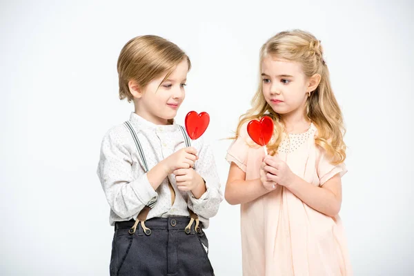 Kids with heart shaped lollipops — Stock Photo