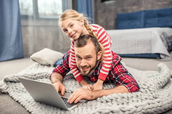 Padre e hija usando laptop - foto de stock