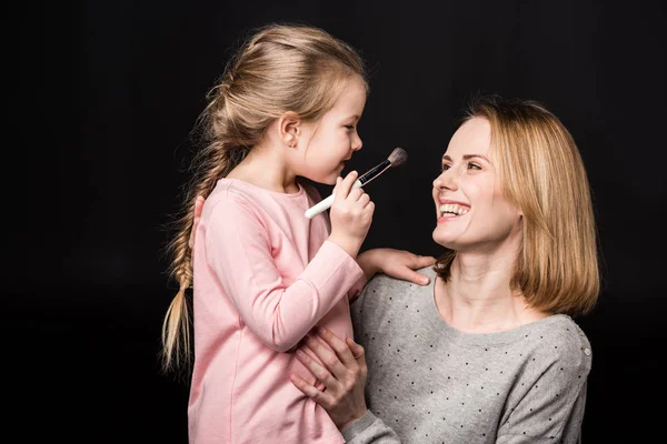 Madre e hija aplicando maquillaje - foto de stock