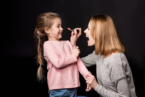 Madre e hija aplicando maquillaje - foto de stock