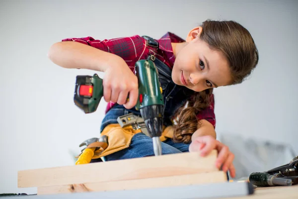 Girl drilling plank — Stock Photo