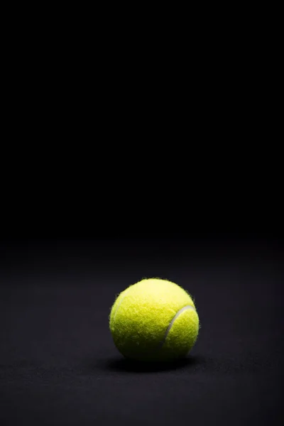 Balle de tennis sur noir — Photo de stock