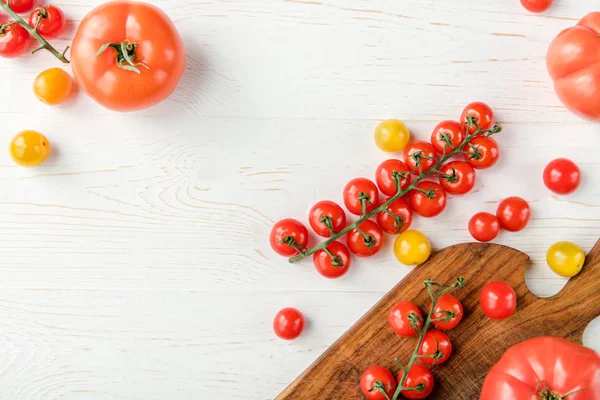 Tomates y tabla de cortar - foto de stock