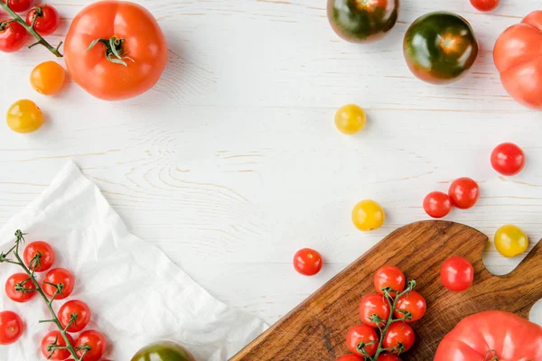 Tomates y tabla de cortar - foto de stock