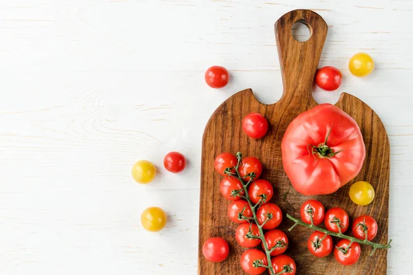 Tomates y tabla de cortar - foto de stock