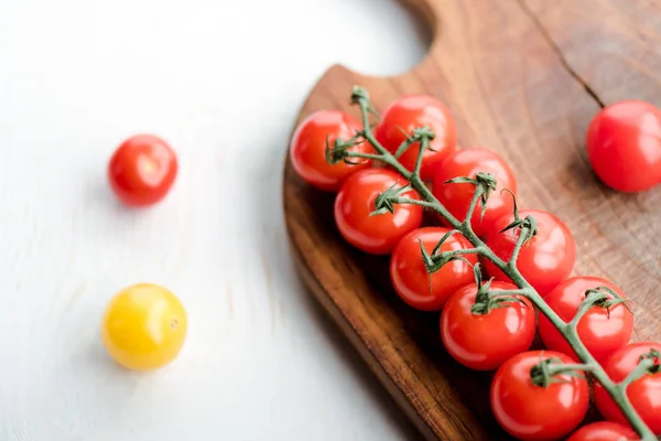 Tomatoes and cutting board — Stock Photo