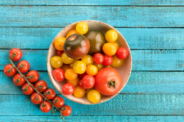 Tomates en tazón en la mesa - foto de stock