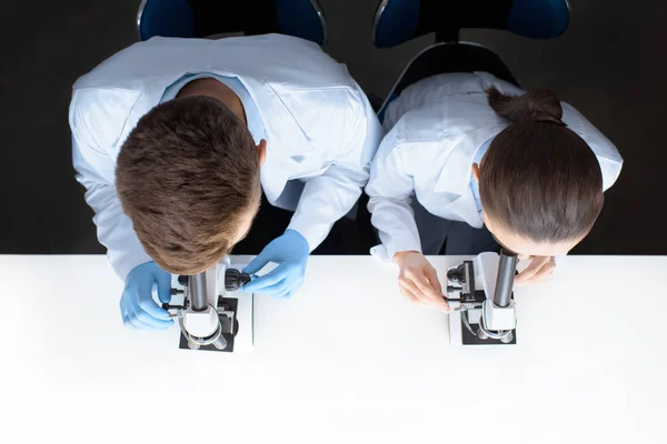 Científicos trabajando con microscopios - foto de stock