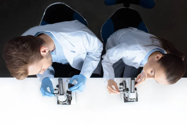 Cientistas que trabalham com microscópios — Fotografia de Stock
