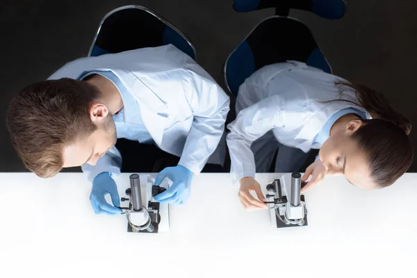 Científicos trabajando con microscopios - foto de stock