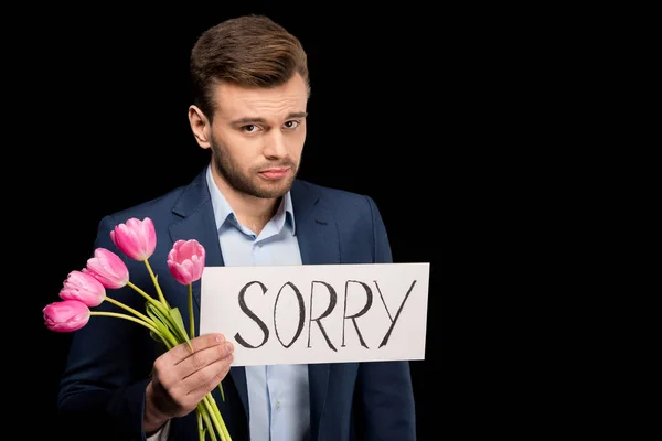 Homme avec des tulipes et signe désolé — Photo de stock